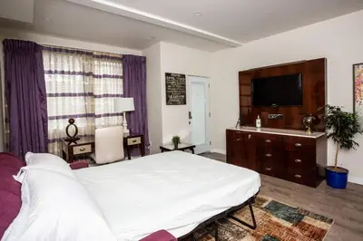 a bedroom with a large white bed and a flat screen tv at 1 Bedroom Apartment with Luxurious Design in SD in San Diego