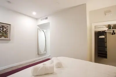 a white bedroom with a bed and a mirror at 1 Bedroom Apartment with Luxurious Design in SD in San Diego