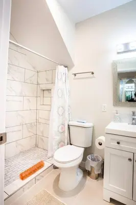 a white bathroom with a toilet and a shower at 1 Bedroom Apartment with Luxurious Design in SD in San Diego