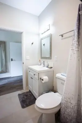 a white bathroom with a toilet and a sink at Studio with Large Balcony- San Diego Gateway in San Diego