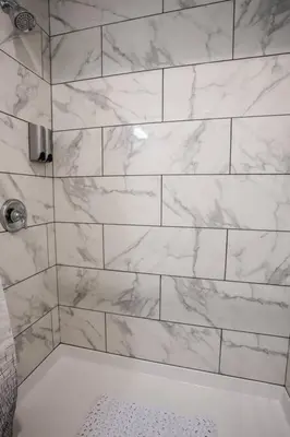 a bathroom with a shower with white marble tiles at Studio with Large Balcony- San Diego Gateway in San Diego
