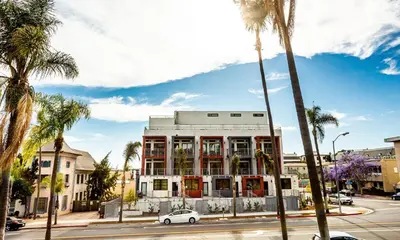a white building on a street with palm trees at Studio with Private Entrance next to Balboa Park in San Diego