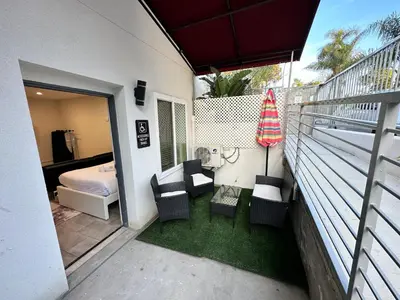 a balcony with chairs and an umbrella and a bedroom at Studio with Private Entrance next to Balboa Park in San Diego