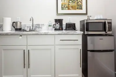 a kitchen with a sink and a microwave and a refrigerator at Explore San Diego-Balboa Park-Little Italy-Gaslamp in San Diego
