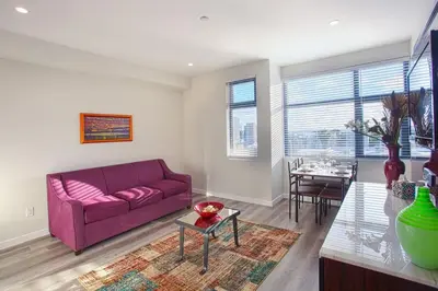 a living room with a purple couch and a table at The Most Beautiful Bay View from 1 Bedroom Apt in San Diego