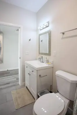 a white bathroom with a toilet and a sink at The Most Beautiful Bay View from 1 Bedroom Apt in San Diego