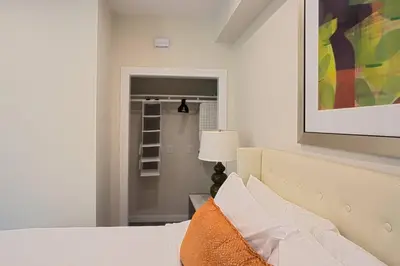 a white bedroom with a bed and a lamp at Luxurious One Bedroom Suite with Balboa Park View in San Diego