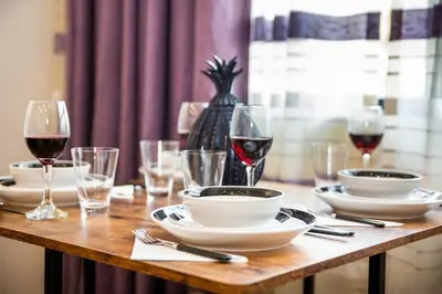 a wooden table with glasses of red wine and plates at Luxurious One Bedroom Suite with Balboa Park View in San Diego
