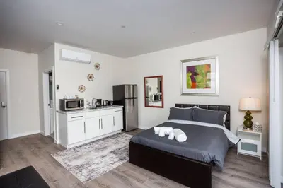 a bedroom with a large bed and a kitchen at Studio with Beautiful View next to Downtown in San Diego