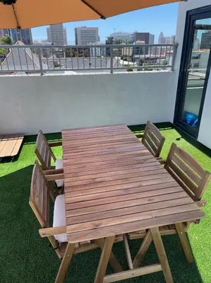 a wooden table and chairs on a balcony with an umbrella at Premier Location with Great Scenic Downtown View in San Diego
