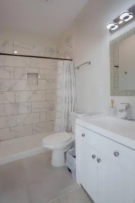a white bathroom with a toilet and a sink at Premier Location with Great Scenic Downtown View in San Diego