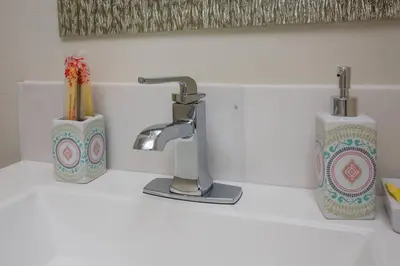 a bathroom counter with a sink with a faucet and tooth brushes at Premier Location with Great Scenic Downtown View in San Diego