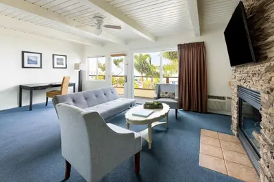 a living room with a couch and a fireplace at Pacific Edge Hotel in Laguna Beach