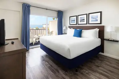 a bedroom with a large bed and a large window at Pacific Edge Hotel in Laguna Beach