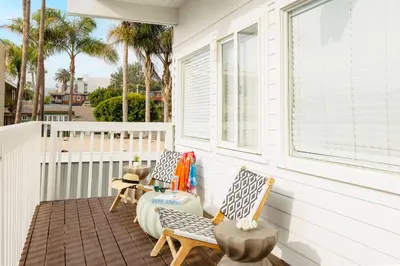 a porch with two chairs and a window at Pacific Edge Hotel in Laguna Beach