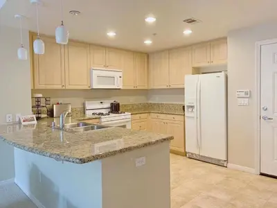 a kitchen with a sink and a white refrigerator at Irvine 2Bedroom 2 Bathroom Apartment with Kitchen Pool gym in Irvine
