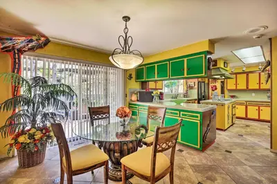 a kitchen with green cabinets and a table and chairs at Colorful El Cajon Gem Deck, Garden and Valley Views in El Cajon