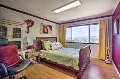 a bedroom with a bed and a chair and a window at Colorful El Cajon Gem Deck, Garden and Valley Views in El Cajon