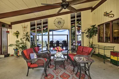 a living room with chairs and a table and a clock at Colorful El Cajon Gem Deck, Garden and Valley Views in El Cajon