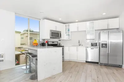 a kitchen with white cabinets and stainless steel appliances at Highly rated Best Beach! AC Luxury KING Beds! in San Diego