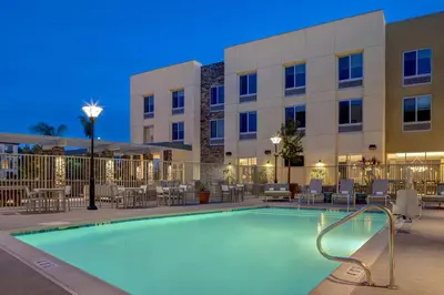 a swimming pool in front of a hotel at night at Hilton Garden Inn Temecula in Temecula