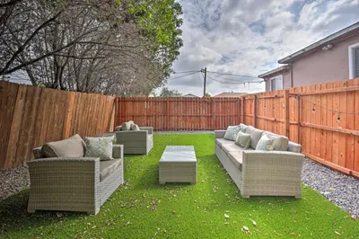 a backyard with two couches and a table and a fence at Modern Duplex Near Gaylord Resort and Bayfront! in Chula Vista