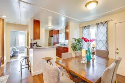 a kitchen and dining room with a wooden table and chairs at 1 Mi to Gaylord Resort and Bayfront Updated Duplex in Chula Vista