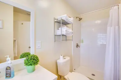a white bathroom with a toilet and a shower at 1 Mi to Gaylord Resort and Bayfront Updated Duplex in Chula Vista