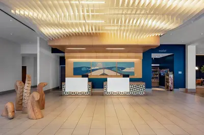 a lobby with a waiting area with chairs and a ceiling at SpringHill Suites by Marriott Oceanside Beach in Oceanside