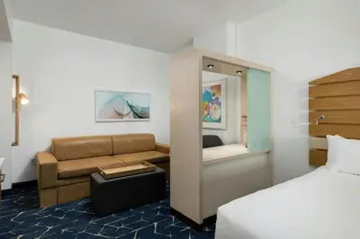 a hotel room with a bed and a couch at SpringHill Suites by Marriott Oceanside Beach in Oceanside