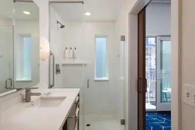 a white bathroom with a sink and a shower at SpringHill Suites by Marriott Oceanside Beach in Oceanside