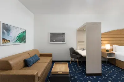 a hotel room with a couch and a bed and a desk at SpringHill Suites by Marriott Oceanside Beach in Oceanside