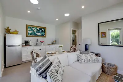 a white living room with a white couch and a kitchen at Serene San Diego Retreat with Deck - Walk to Bay! in San Diego