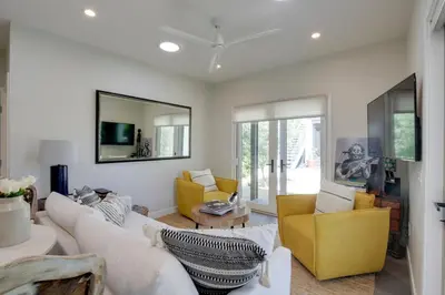 a living room with white furniture and a yellow chair at Serene San Diego Retreat with Deck - Walk to Bay! in San Diego