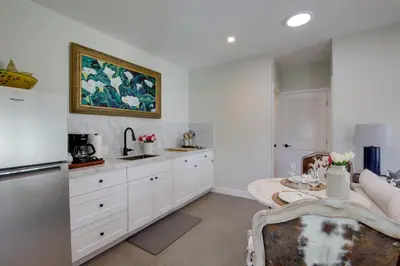 a kitchen with white cabinets and a table at Serene San Diego Retreat with Deck - Walk to Bay! in San Diego