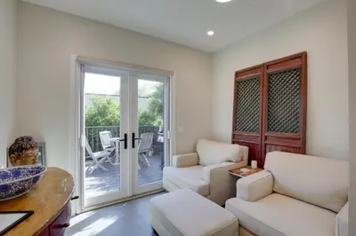 a living room with white furniture and a sliding glass door at Serene San Diego Retreat with Deck - Walk to Bay! in San Diego