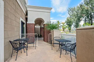 a patio with tables and chairs on a balcony at La Quinta by Wyndham Temecula in Temecula