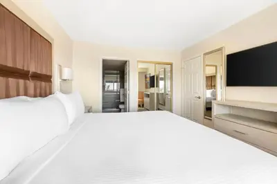 a bedroom with a large white bed and a flat screen tv at Hilton Vacation Club Riviera Beach & Shores in Capistrano Beach