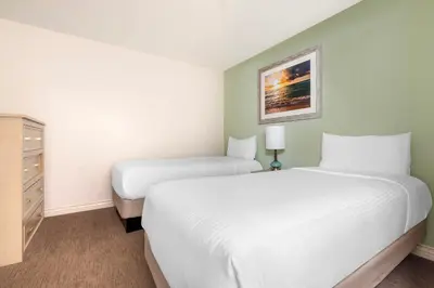 a hotel room with two beds and a dresser at Hilton Vacation Club Riviera Beach & Shores in Capistrano Beach