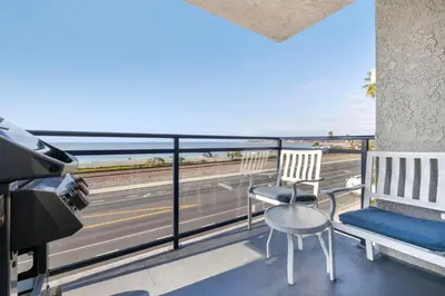 a balcony with two chairs and a couch and a highway at Hilton Vacation Club Riviera Beach & Shores in Capistrano Beach