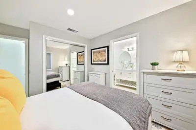 a bedroom with a white bed and two mirrors at Enchanting Cottage By the Sea in Carlsbad