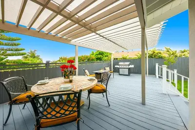 a patio with a table and chairs on a deck at Enchanting Cottage By the Sea in Carlsbad