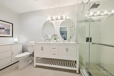 a white bathroom with a toilet and a shower at Enchanting Cottage By the Sea in Carlsbad