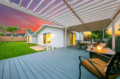 an outdoor deck with a pergola with a table and chairs at Enchanting Cottage By the Sea in Carlsbad