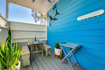 a patio with a table and a blue wall at Mission Beach Getaway in San Diego