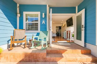 a blue house with a table and chairs on a porch at Mission Beach Getaway in San Diego