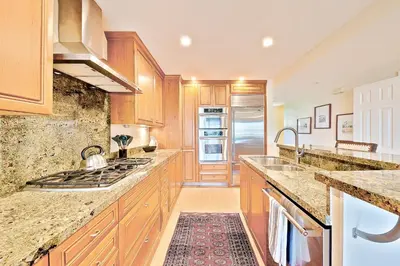 a kitchen with wooden cabinets and granite counter tops at Sea & Sand Ocean Views in San Diego