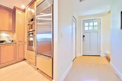 a kitchen with a stainless steel refrigerator and wooden cabinets at Sea & Sand Ocean Views in San Diego