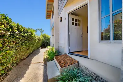 a white door on a white house with a porch at Sea & Sand Ocean Views in San Diego