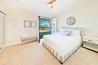 a white bedroom with a bed and a balcony at Sea & Sand Ocean Views in San Diego